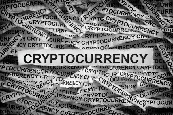 Cryptocurrency. Torn pieces of paper with the word Cryptocurrency. Black and white. Close up.
